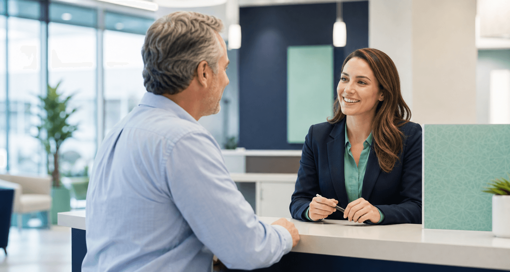 Bank teller speaking with a customer at a branch counter